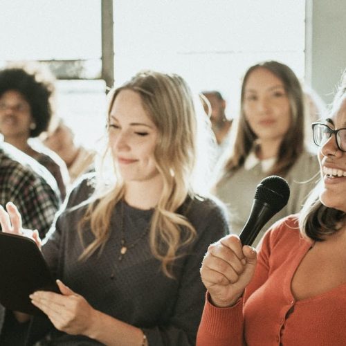 Cheerful woman speaking on a microphone in a workshop