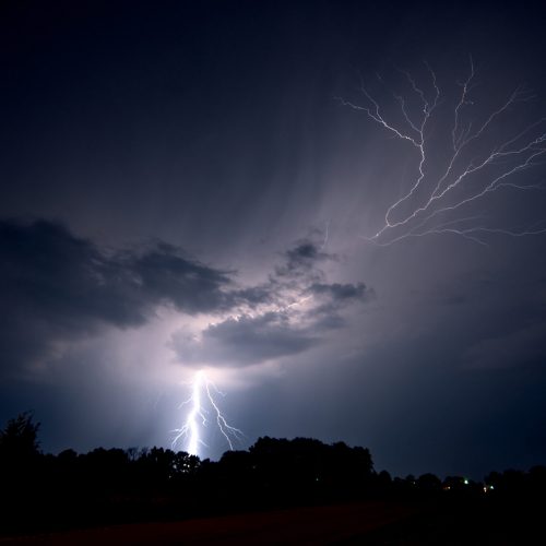 Lightning strikes the ground and spreads into the sky as a lightning crawler nears Jeanette, Arkansas, USA